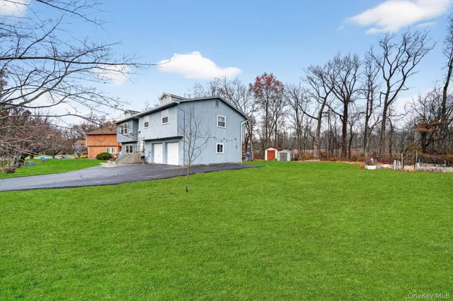 a view of a house with a big yard and large trees
