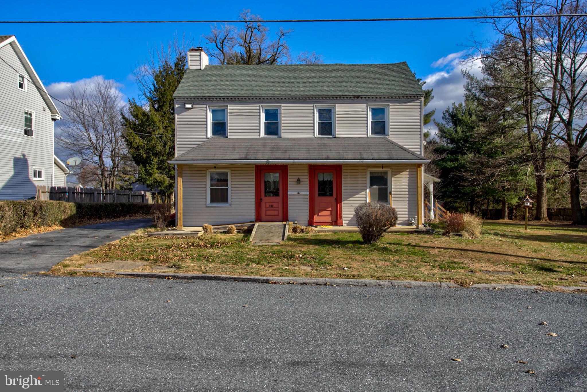 a view of a house with a yard and large tree