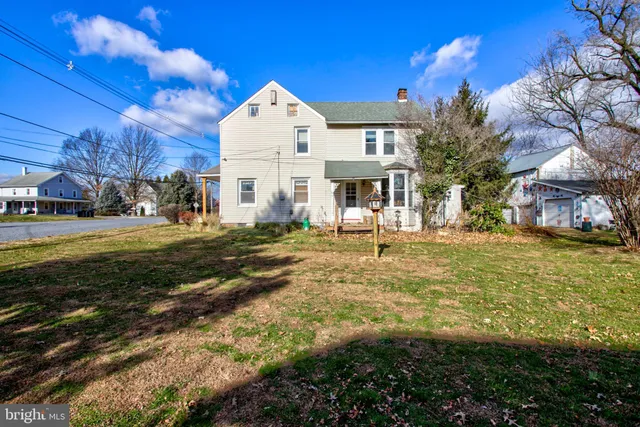 a view of a house with a small yard and wooden fence