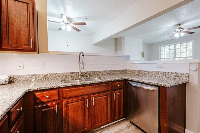 a kitchen with stainless steel appliances granite countertop a sink a stove cabinets and a counter top space