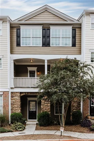 a front view of a house with a tree