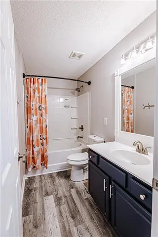 a bathroom with a double vanity sink toilet mirror and bathtub