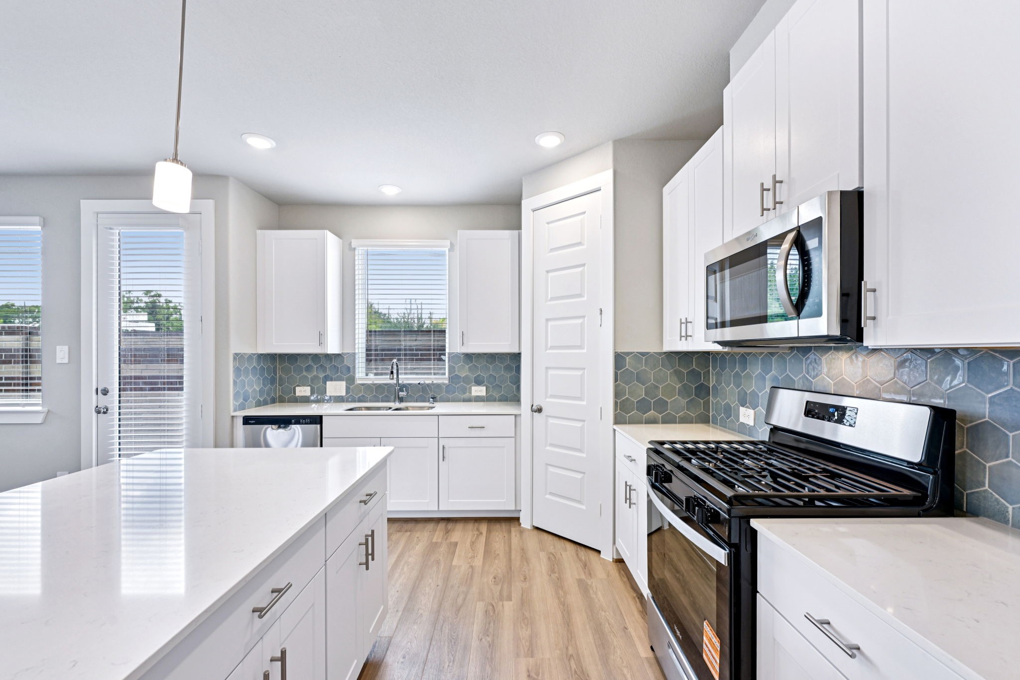10032 Rustic Charm Street Houston, TX 77080 - Photo 11 of 40 a kitchen with stainless steel appliances white cabinets sink stove and microwave