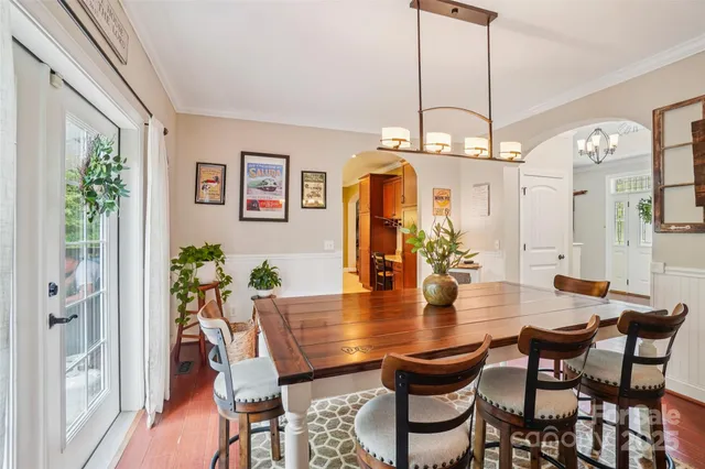 a view of a dining room with furniture a chandelier and wooden floor