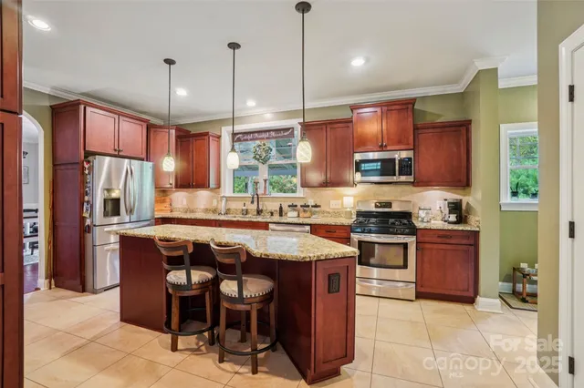 a kitchen with stainless steel appliances granite countertop a stove a sink a oven a dining table and chairs
