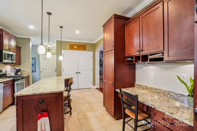 a kitchen with granite countertop a stove a sink and a refrigerator