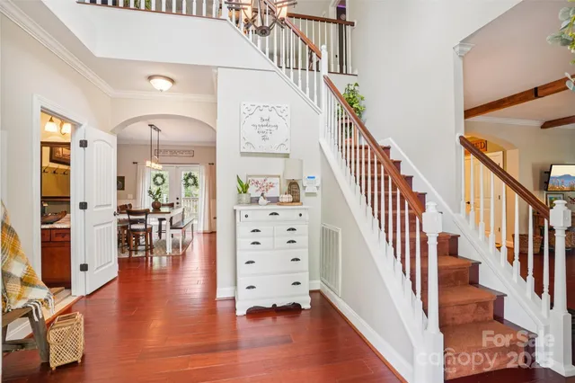 a view of staircase with lots of frames on wall and wooden floor