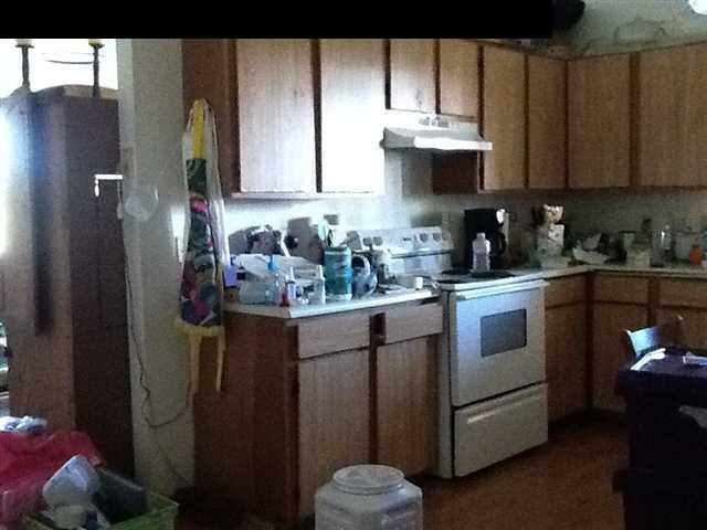 944 Kokomo Road Haiku, HI 96708 - Photo 10 of 11 a kitchen with stainless steel appliances granite countertop a refrigerator sink and cabinets