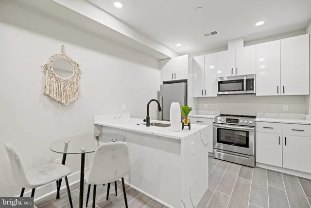 a kitchen with stainless steel appliances a sink and a refrigerator