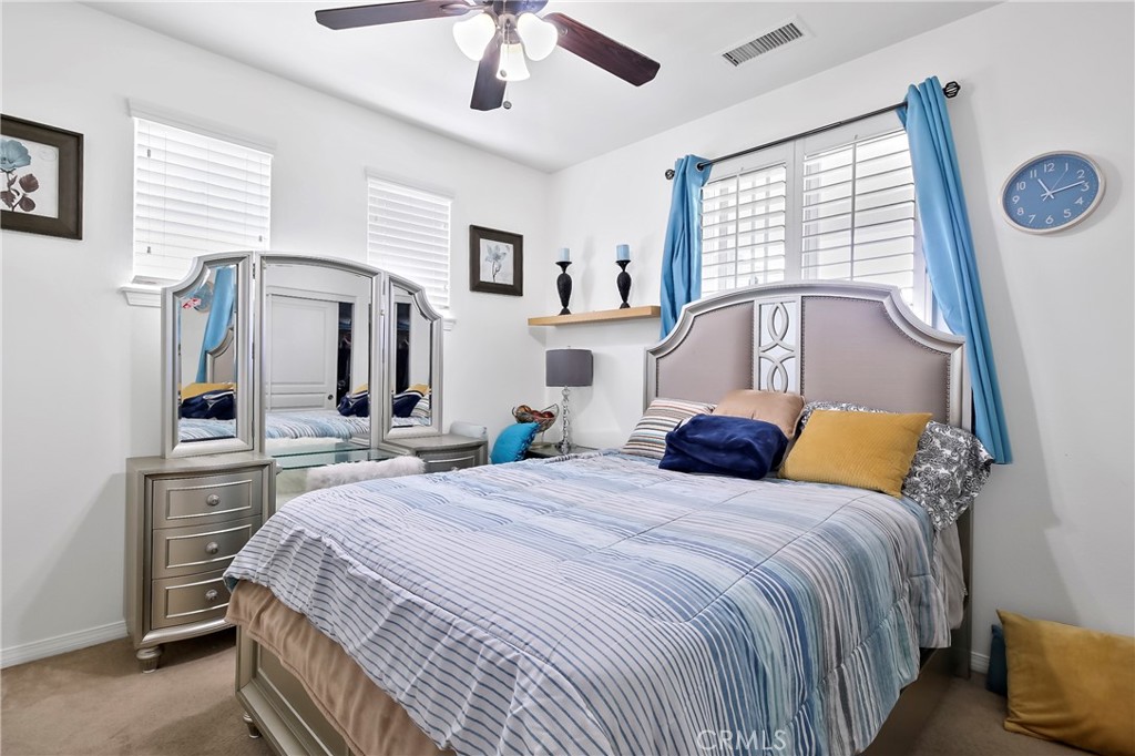 32001 Whitetail Lane Temecula, CA 92592 - Photo 11 of 28 a bedroom with a bed a mirror on dresser with wooden floor