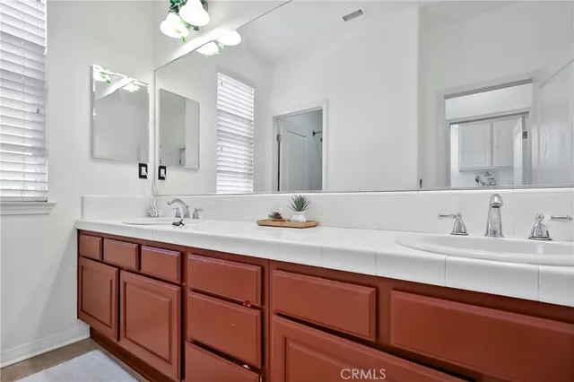 a bathroom with double vanity sinks and a mirror