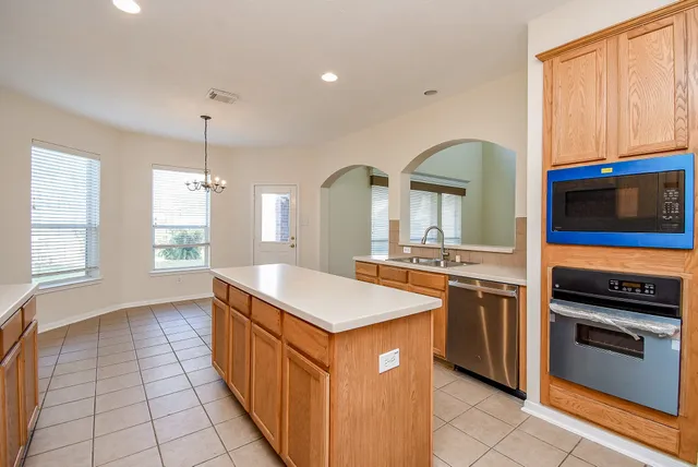 a kitchen with stainless steel appliances granite countertop a stove a sink and a microwave