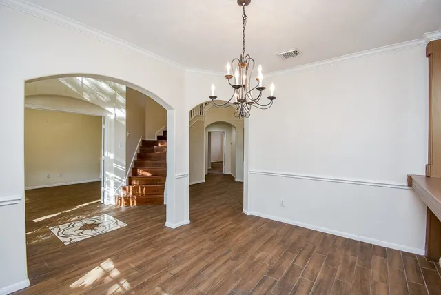 a view of a room with wooden floor and chandelier
