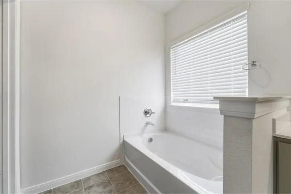 a bathroom with a bathtub and a window