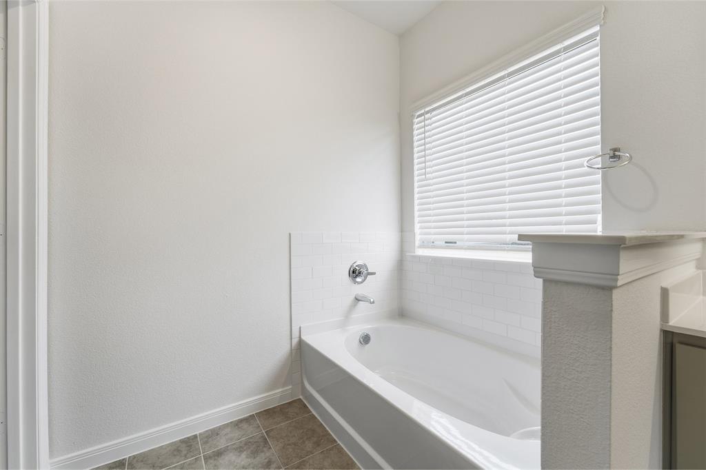 232 Triple Crown Road Waxahachie, TX 75165 - Photo 17 of 22 a bathroom with a bathtub and a window