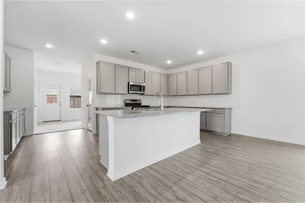 a kitchen with a refrigerator and a stove top oven