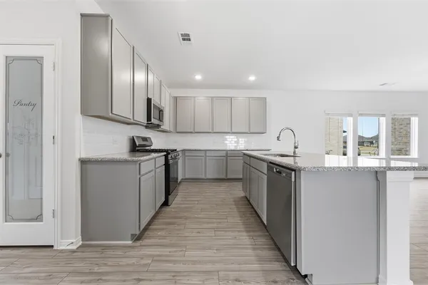a kitchen with stainless steel appliances granite countertop a sink and cabinets