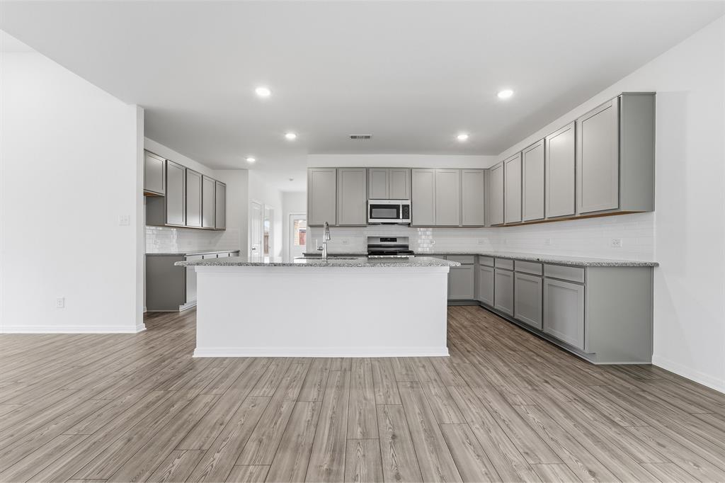 232 Triple Crown Road Waxahachie, TX 75165 - Photo 10 of 22 a large kitchen with cabinets wooden floor and a window