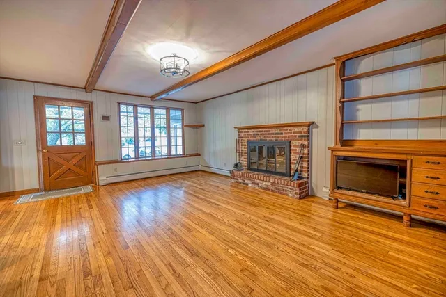 wooden floor fireplace and windows in an empty room