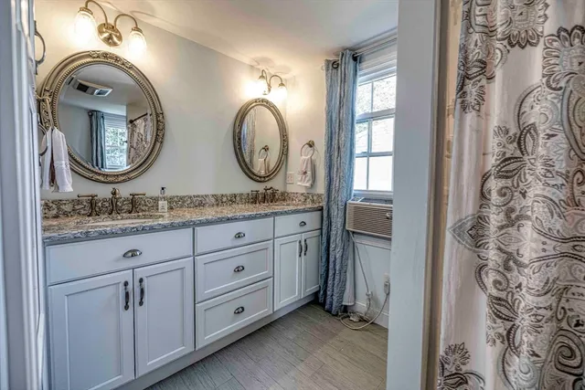 a bathroom with a granite countertop mirror and a sink