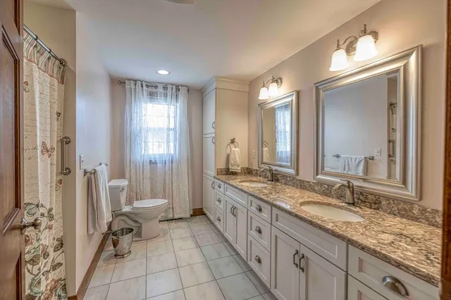 a spacious bathroom with a granite countertop sink mirror and a