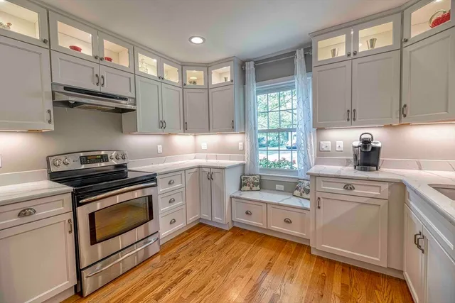 a kitchen with cabinets stainless steel appliances and wooden floor