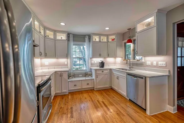 a kitchen with stainless steel appliances granite countertop a refrigerator a stove and a sink