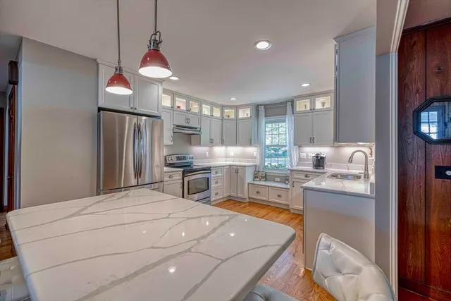 a kitchen with stainless steel appliances a refrigerator sink and wooden floor