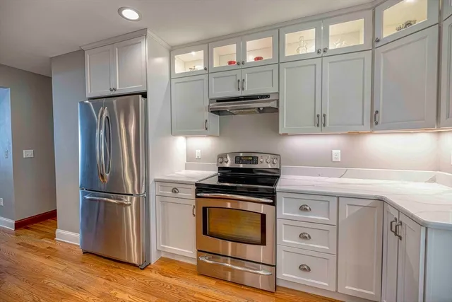 a kitchen with appliances cabinets and a wooden floor