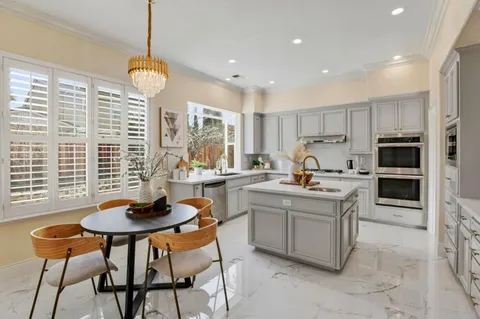 a kitchen with a sink a counter top space and living room view