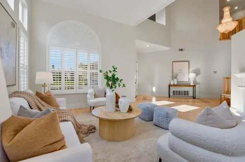 a living room with furniture a fireplace and a large window