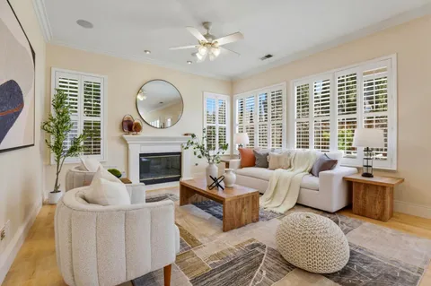 a living room with furniture a fireplace and a large window