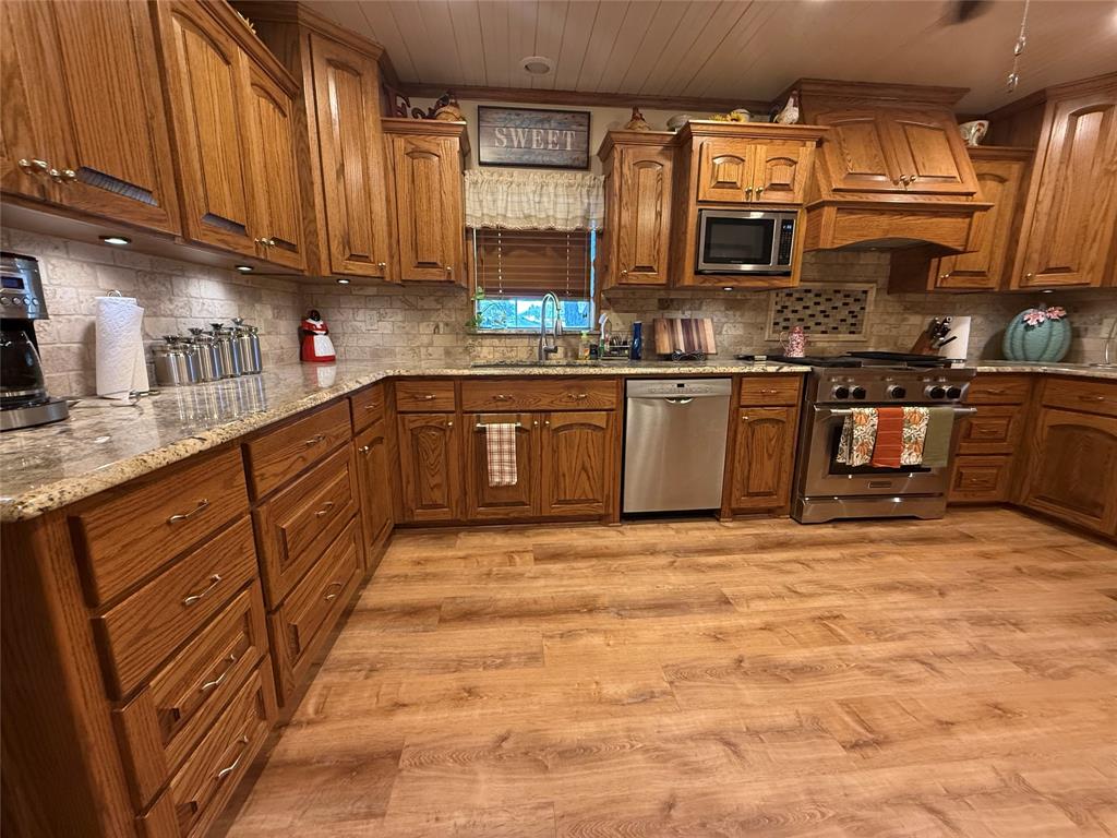 908 North Austin Street Comanche, TX 76442 - Photo 11 of 37 a kitchen with stainless steel appliances granite countertop a stove sink and cabinets