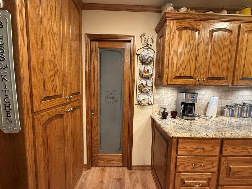 908 North Austin Street Comanche, TX 76442 - Photo 12 of 37 a kitchen with a refrigerator and cabinets