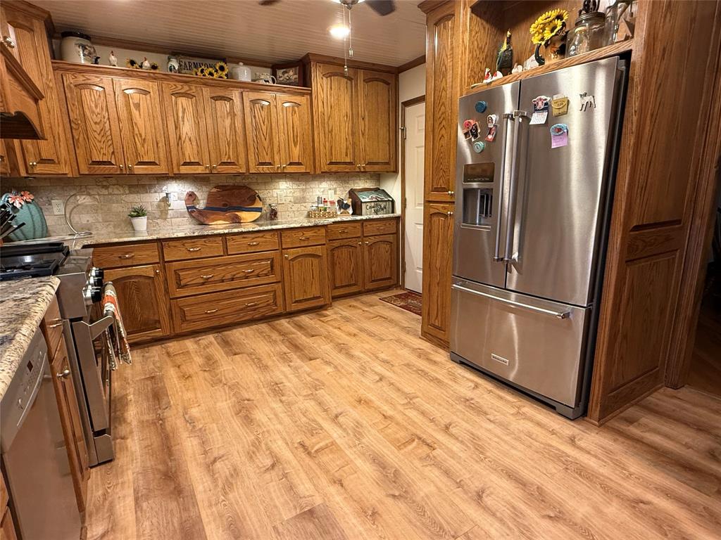 908 North Austin Street Comanche, TX 76442 - Photo 13 of 37 a kitchen with stainless steel appliances granite countertop a refrigerator a sink and white cabinets