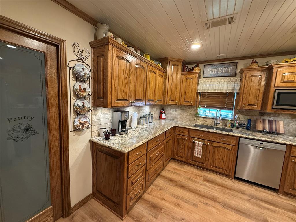 908 North Austin Street Comanche, TX 76442 - Photo 14 of 37 a kitchen with stainless steel appliances granite countertop a sink stove and refrigerator