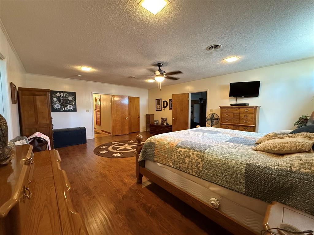 908 North Austin Street Comanche, TX 76442 - Photo 16 of 37 a bedroom with a bed and a flat screen tv
