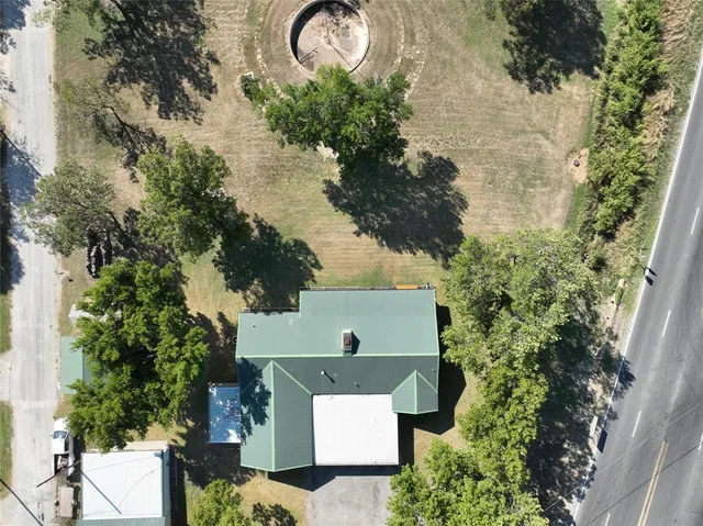 an aerial view of a house with a yard and large tree