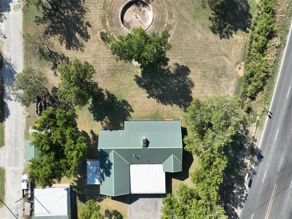 908 North Austin Street Comanche, TX 76442 - Photo 2 of 37 an aerial view of a house with a yard and large tree