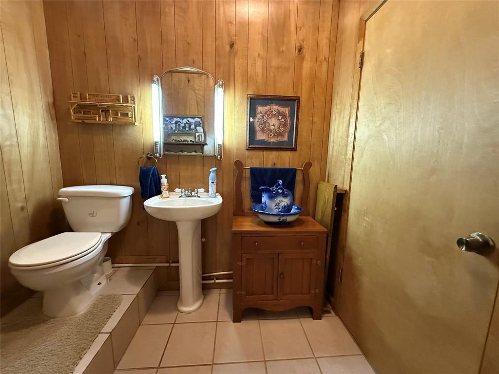 908 North Austin Street Comanche, TX 76442 - Photo 23 of 37 a bathroom with a toilet sink and mirror