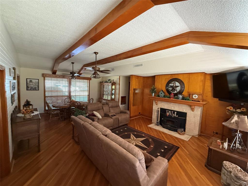 908 North Austin Street Comanche, TX 76442 - Photo 7 of 37 a living room with furniture a flat screen tv and a fireplace