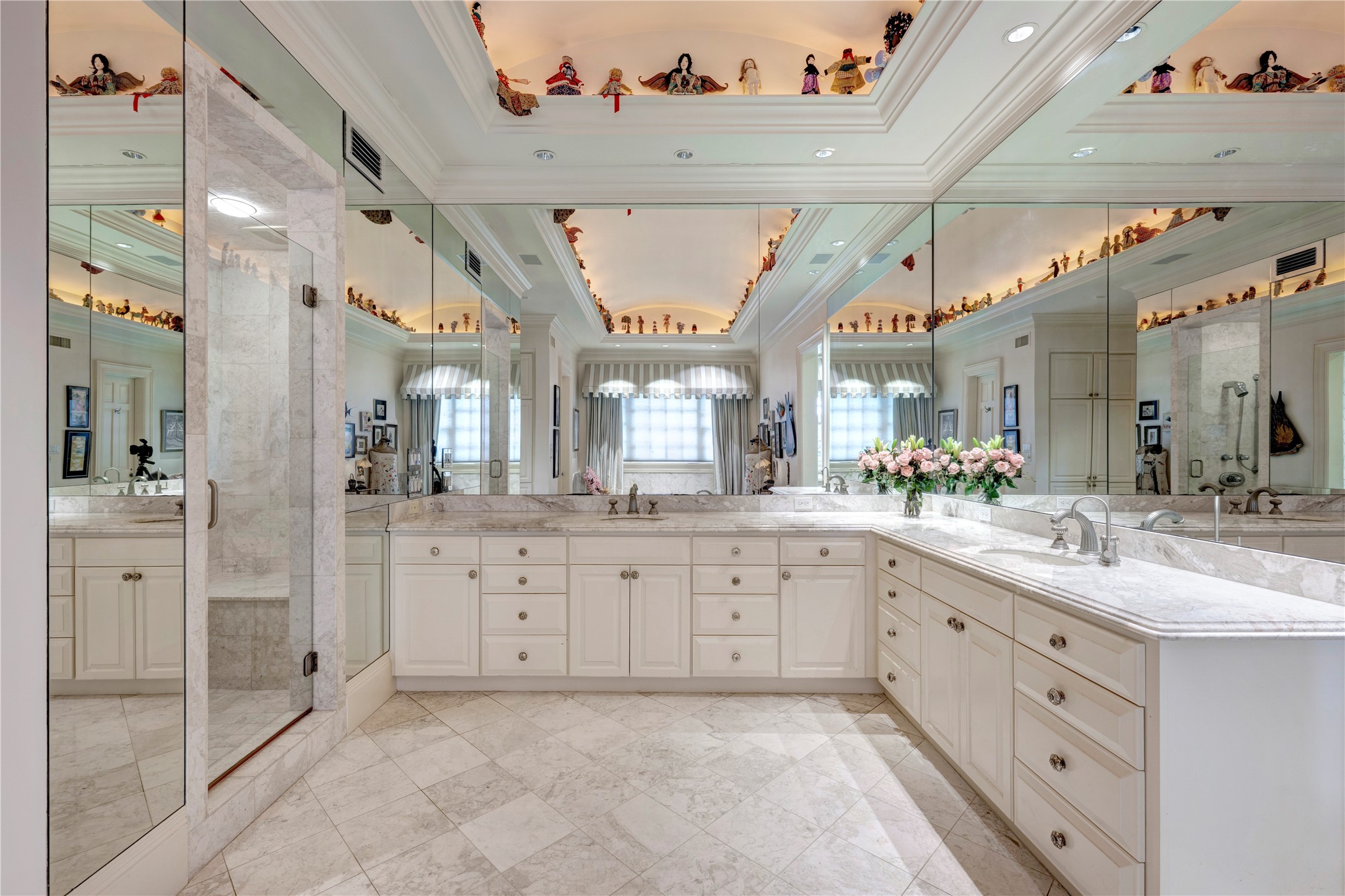 3653 Inverness Drive Houston, TX 77019 - Photo 24 of 39 The primary bath has a domed ceiling with cove lighting, marble vanities with two sinks, pretty marble flooring, and a walk-in shower with a seat.