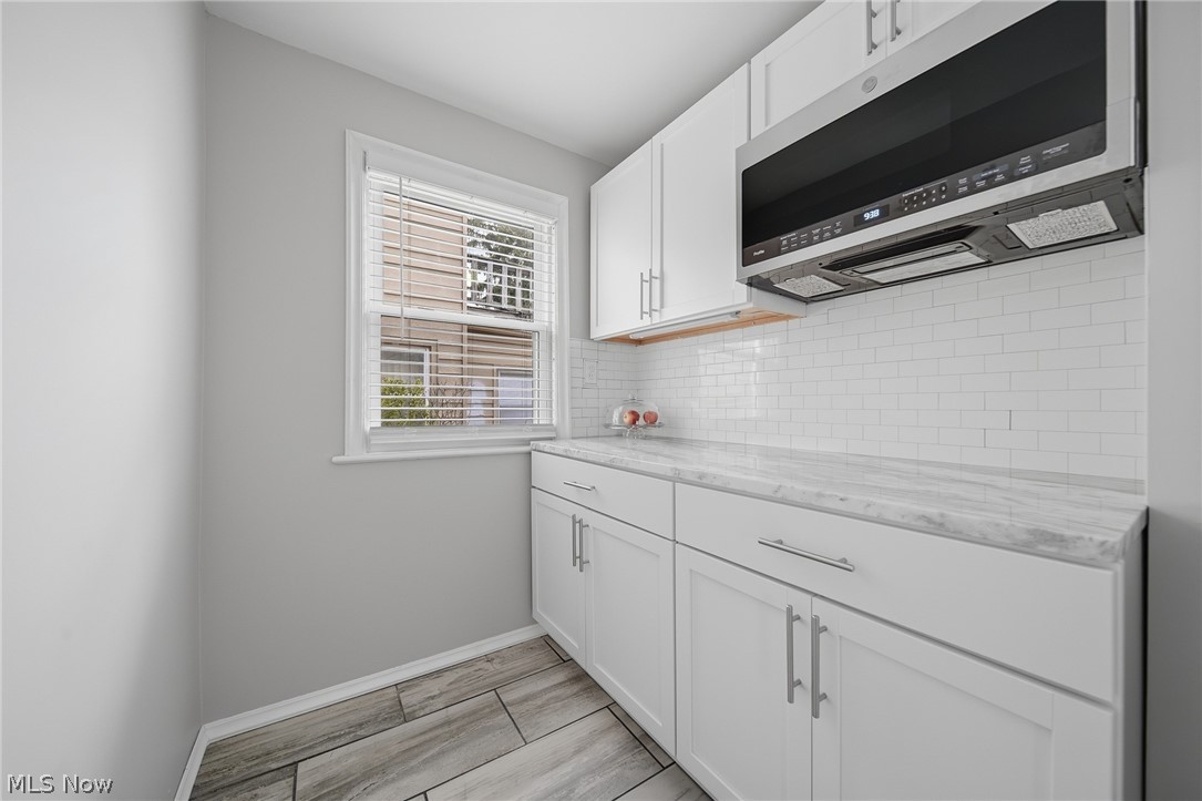 2231 Brockway Road University Heights, OH 44118 - Photo 12 of 46 Kitchen featuring white shaker-style cabinetry, a white subway tile backsplash, and light-toned countertops