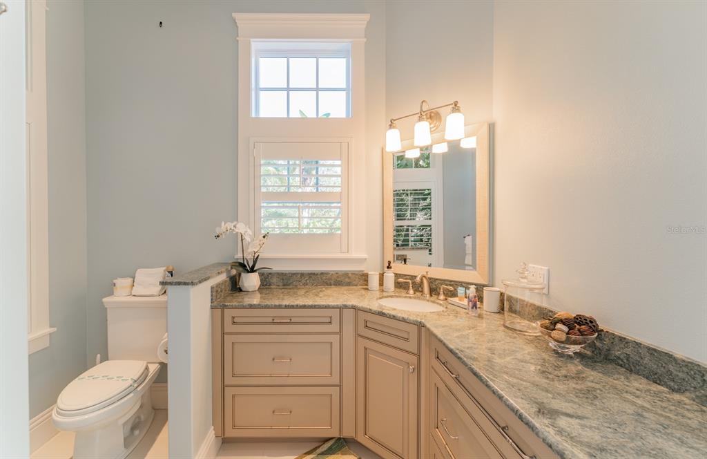 714 Jacaranda Road Anna Maria, FL 34216 - Photo 26 of 100 a bathroom with a granite countertop sink toilet and mirror