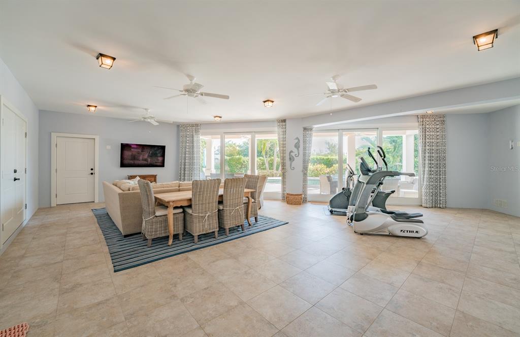 714 Jacaranda Road Anna Maria, FL 34216 - Photo 54 of 100 a living room with furniture a large window and a flat screen tv