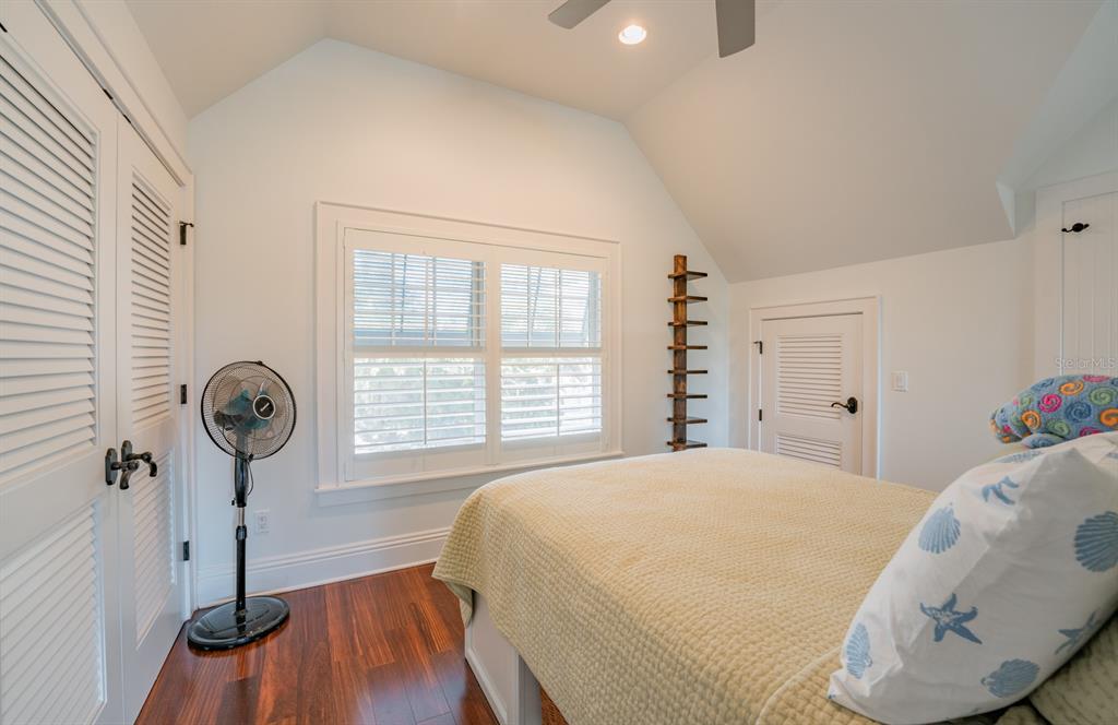 714 Jacaranda Road Anna Maria, FL 34216 - Photo 66 of 100 a bedroom with a bed a chandelier and a window