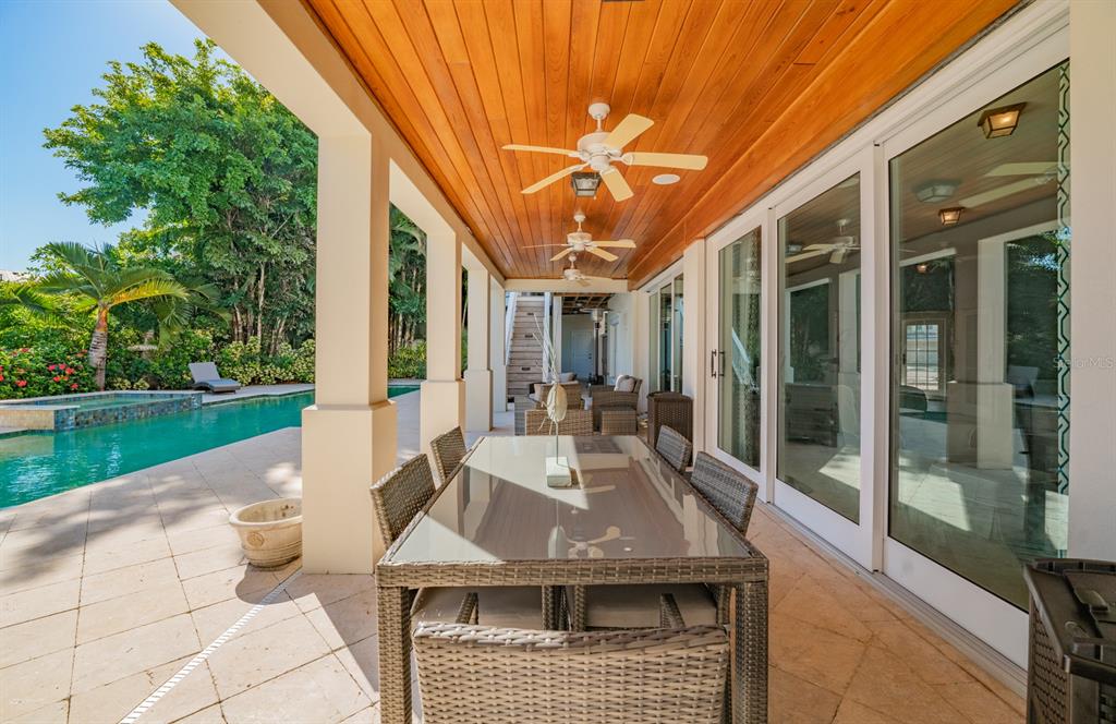 714 Jacaranda Road Anna Maria, FL 34216 - Photo 84 of 100 a view of a patio with table and chairs potted plants with floor to ceiling window and garden