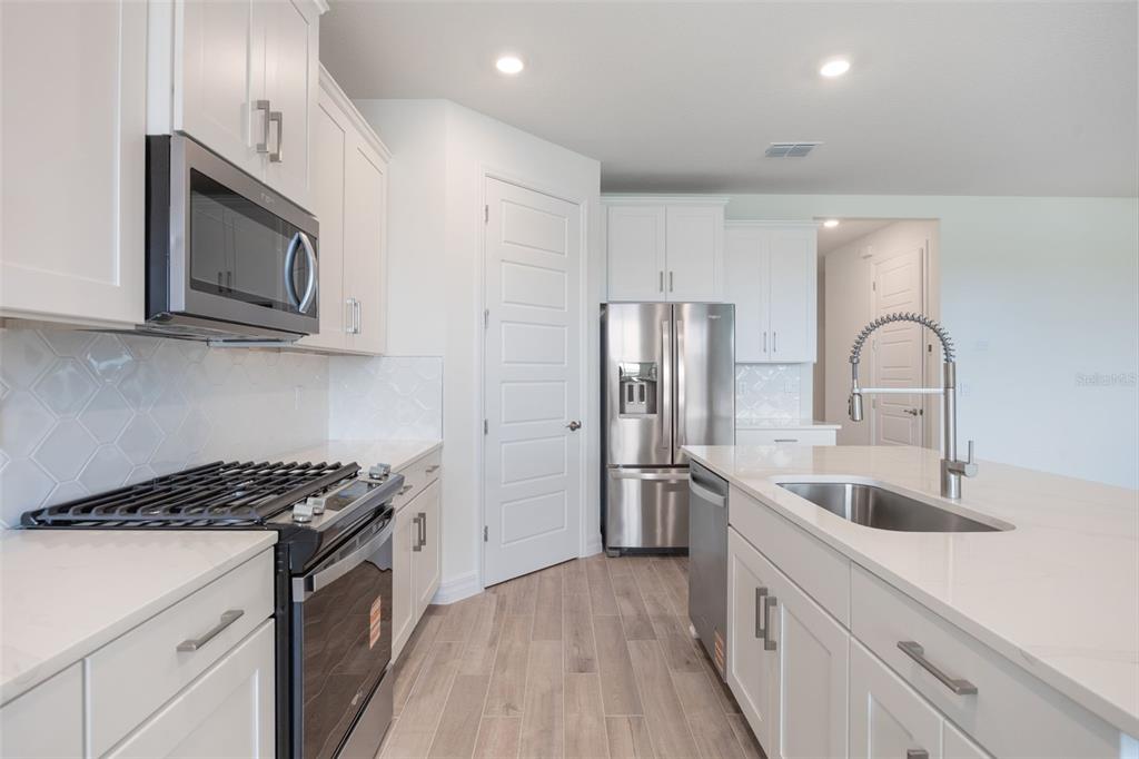 2277 Hamden Way Mount Dora, FL 32757 - Photo 12 of 32 a kitchen with stainless steel appliances granite countertop a sink stove and refrigerator