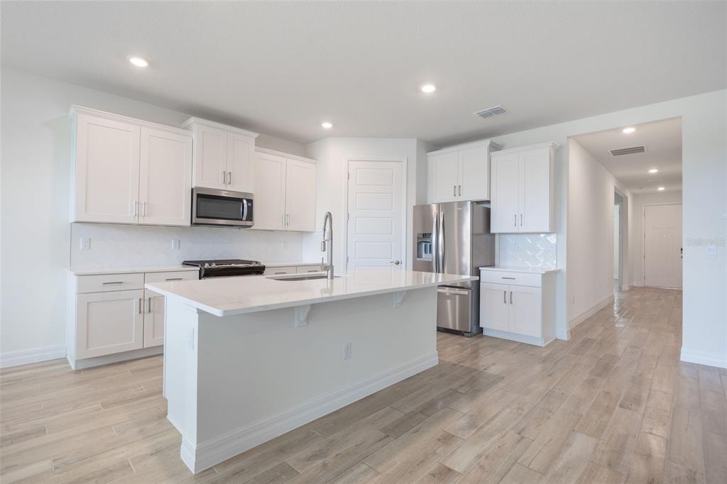2277 Hamden Way Mount Dora, FL 32757 - Photo 14 of 32 a kitchen with stainless steel appliances a refrigerator a stove top oven a sink and cabinets