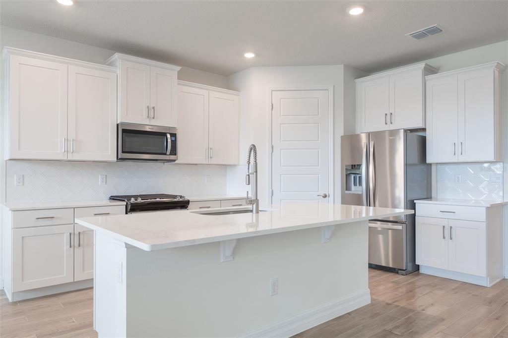 2277 Hamden Way Mount Dora, FL 32757 - Photo 15 of 32 a kitchen with stainless steel appliances white cabinets and a refrigerator